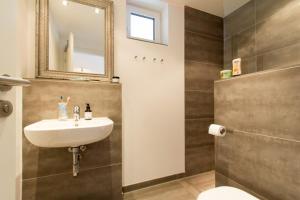 a bathroom with a sink and a toilet and a mirror at Skipperlodge - Versteck am Strom in Warnemünde +14 photos