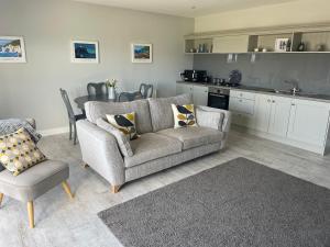 ein Wohnzimmer mit Couch und Küche in der Unterkunft Portview in Portrush