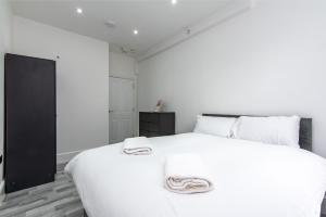 ein Schlafzimmer mit einem großen weißen Bett mit weißen Kissen in der Unterkunft 1-Bed Apartment near Bradford City Centre in Bradford