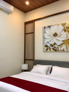a bedroom with a bed with a flower painting on the wall at Van Bloemen 1881 Resort in Kembanglimus +7 photos