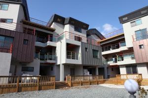 an apartment building with a wooden fence in front of it at Healing Village Pension in Gyeongju
