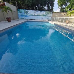 a swimming pool with blue water in front of a wall at COP 30 Casa luxo mobiliada em condomínio in Ananindeua