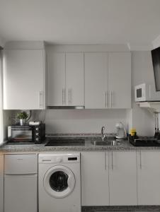 a white kitchen with a washing machine in it at Apartamento Puertomar in El Puerto de Santa María