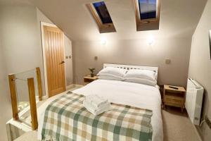 a bedroom with a white bed with a checkered blanket at Thistle Nook in Coldstream
