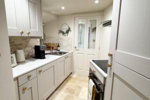 a kitchen with white cabinets and a sink at Thistle Nook in Coldstream