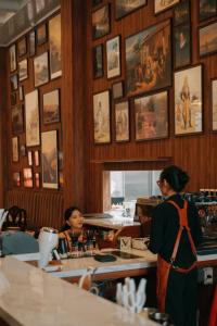 two women standing at a counter in a restaurant at Van Bloemen 1881 Resort in Kembanglimus