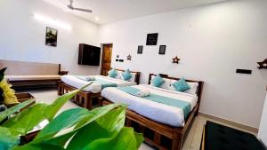 a room with two beds with blue pillows at THE LUXE - Pondicherry - BMC in Pondicherry +81 photos