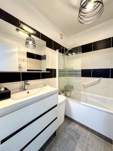 a bathroom with a sink and a tub and a toilet at Villa Bel Air - appartement avec jardin et parking in Chartres +8 photos