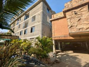 a large building with plants in front of it at Kirungi Vacation Homes - Large Bamboo Studio room with access to top roof in Fort Portal
