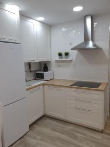 a white kitchen with white cabinets and a microwave at Your dream vacation in Fuengirola