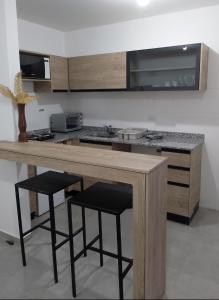 eine Küche mit einer Holztheke mit Hockern in der Unterkunft Centro Carlos Paz Cibeles in Villa Carlos Paz