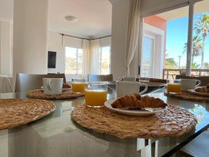 a dining room with a table with food and orange juice at Brisa Vacacional - Adults Only in Corralejo