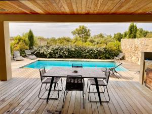 a patio with a table and chairs next to a pool at Villa Mare piscine et spa in Zonza