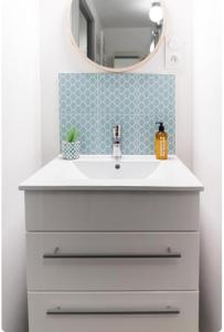 un baño con lavabo y espejo en Lafayette Bohème chic, en Lyon