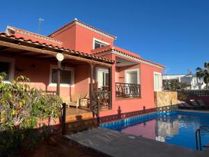a house with a swimming pool in front of it at Brisa Vacacional - Adults Only in Corralejo