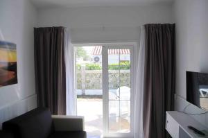 sala de estar con puerta corredera de cristal que da a un patio en Bungalows Los Arcos, en Playa del Inglés