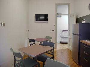 a room with a table and chairs and a refrigerator at Aurora Rooms in Parma