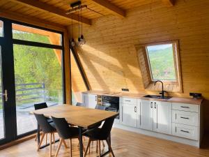a kitchen with a table and chairs in a room at Sălciuella Dream Cabin in Sălciua de Jos