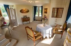 a living room with a table and chairs and a desk at La Folie in Modave