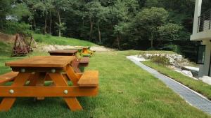a group of picnic tables sitting on the grass at Ganghwado Baba Valley Pension in Incheon