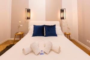 アラッシオにあるLa Casa di Via Colombo 6の白いベッド(青い枕2つ付)