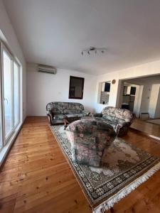 Una sala de estar con dos sofás y una alfombra. en Moonlight House, en Visoko