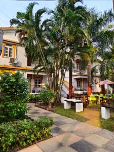 a resort with tables and palm trees and a building at Beachside Studio 302 - Calangute Goa in Calangute