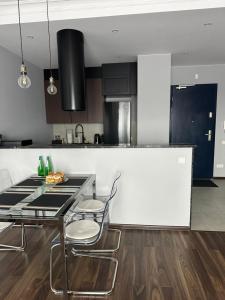 een keuken met een tafel en stoelen en een aanrecht bij Apartament Szarlotka in Łódź