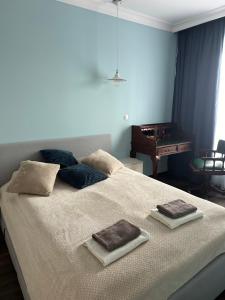 een slaapkamer met een groot bed met twee handdoeken erop bij Apartament Szarlotka in Łódź