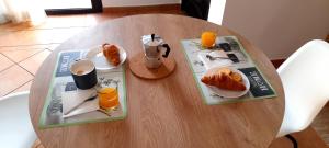 einem Holztisch mit zwei Teller Essen und Orangensaft in der Unterkunft Casa Vale in Majanicho