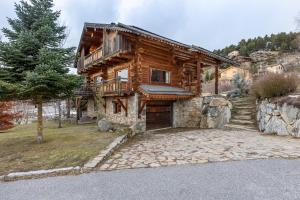 a log cabin with a porch and stairs to it at Chalet des Sonnailles - Montagnes jardin et garage in Bolquere Pyrenees 2000