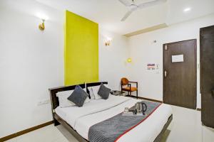 a bedroom with a bed and a green wall at Collection O Riddhi Siddhi in Vadodara