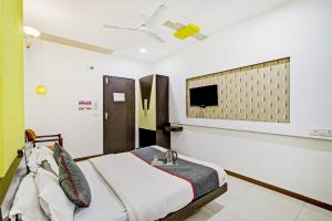a bedroom with a bed and a tv on the wall at Collection O Riddhi Siddhi in Vadodara +8 photos