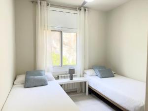 zwei Betten in einem Zimmer mit Fenster in der Unterkunft Atico Isabel in Castelldefels + 18 Fotos