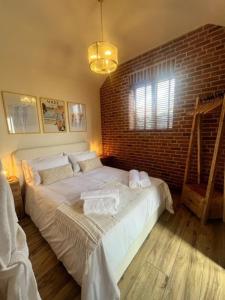 East StokeにあるThe Beautiful Barnのレンガの壁のベッドルーム1室(大型ベッド1台付) +39枚の写真