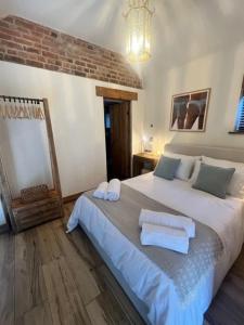 East StokeにあるThe Beautiful Barnのタオルが敷かれた大きなベッドのある寝室