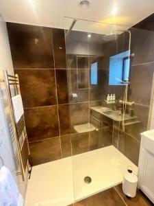 a shower with a glass door in a bathroom at The Beautiful Barn in East Stoke +39 photos