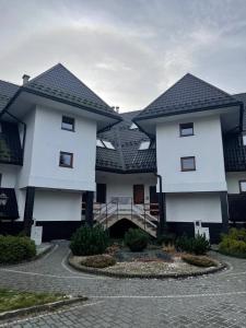 un edificio blanco con techo negro en Mini-apartment z pięknym widokiem na Tatry, en Murzasichle