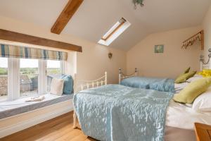 zwei Betten in einem Schlafzimmer mit Fenster in der Unterkunft Webbington Farm Cottages in Loxton
