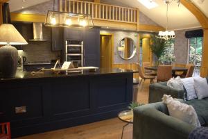 a kitchen and living room with a large island at Norway Spruce Lodge - The Hollies Retreats in Oakmere