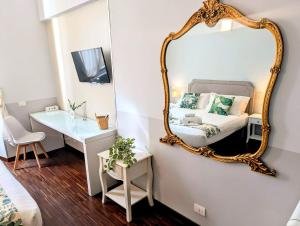 a mirror on a wall with a bed and a desk at DM69 - Termini Monti Crossroads in Rome