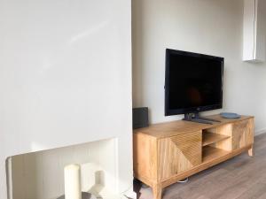 einen Flachbild-TV auf einem hölzernen Entertainment-Center in der Unterkunft Atico Isabel in Castelldefels