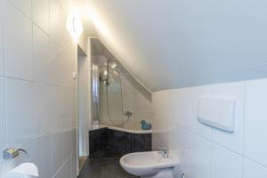 a white bathroom with a sink and a toilet at Vakantiehuis Siedling in Winterberg +18 photos