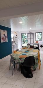a kitchen with a table and chairs in a room at La familiale in Salazie