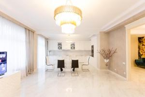 a dining room with a table and chairs and a chandelier at Luxury Apartment For Families Or Group of Visitors In City Center I in Tbilisi City +26 photos
