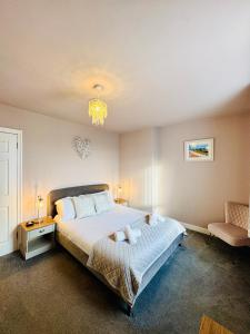 a bedroom with a large bed and a chandelier at HomeDecor Cottages - The Sands Cottage in Seahouses