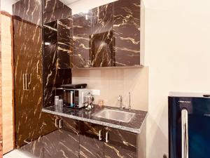 a kitchen with a sink and a microwave at Golden palace studio in Ghaziabad