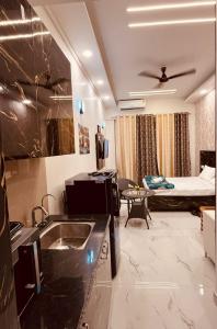 a kitchen and living room with a bed in a room at Golden palace studio in Ghaziabad