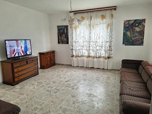 een woonkamer met een bank en een flatscreen-tv bij CasaWhite in San Vito Chietino