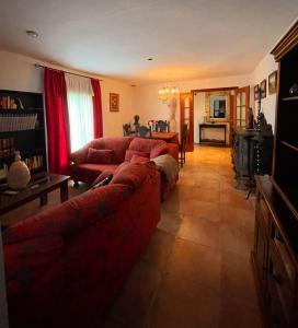 a living room with a red couch and a table at Villa La Luna CHALET COMPLETO in Guadajira